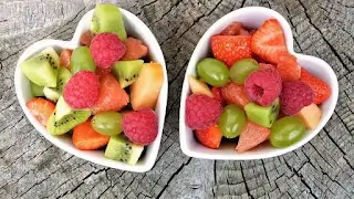 Fresh seasonal fruits including kiwi, strawberries, grapes, and raspberries for healthy glowing skin